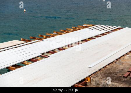 Il molo dove il ponte bianco composito è installato vicino al mare. Foto Stock