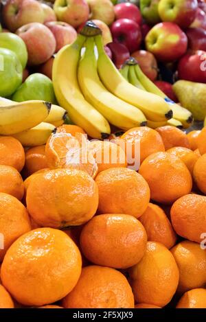 I tangerini, le banane e le mele sono maturi al banco di vendita. Foto Stock