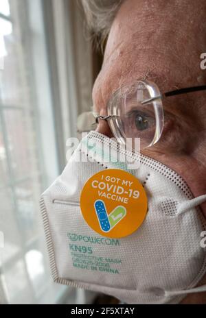 Uomo anziano con un adesivo "ho ottenuto il mio vaccino COVID-19" sulla sua maschera protettiva KN95, Stati Uniti Foto Stock