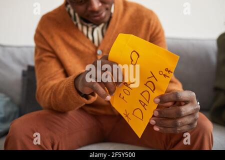 Primo piano della lettera di apertura dell'uomo afroamericano per il papà come regalo fatto a mano per il giorno dei Padri, spazio di copia Foto Stock