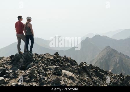 Coppia che guarda la vista dalla vetta della montagna contro il cielo limpido durante le vacanze Foto Stock