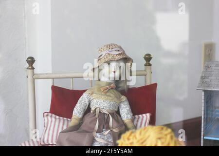 Bambola in porcellana d'epoca, vestita con cappello in un vetrina curiosità Foto Stock