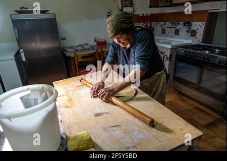 la nonna arrotola l'impasto appena impastato Foto Stock