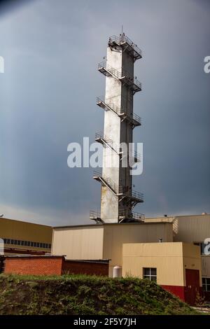 Sokolovo-Sarbay stabilimento minerario e di lavorazione. Torre in cemento grigio con scale sul cielo grigio. Visione industriale astratta. Foto Stock