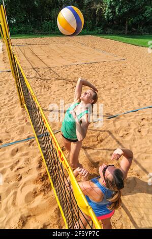 Gioco competitivo sul campo da pallavolo di spiaggia al netto Foto Stock