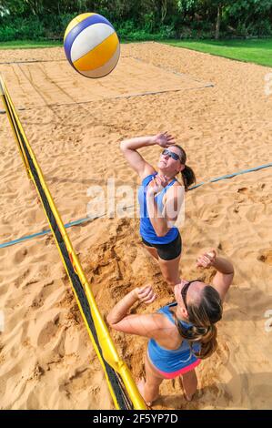 Gioco competitivo sul campo da pallavolo di spiaggia al netto Foto Stock