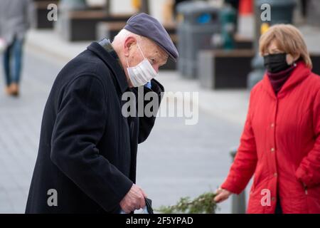 Uomo anziano che indossa una maschera in città Foto Stock