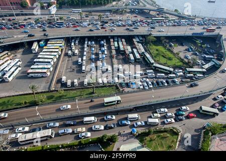 Il traffico arriva a un giro sulle strade del centro del Cairo in Egitto nel tardo pomeriggio. In centro si trova una stazione degli autobus. Foto Stock