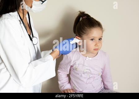 chubby bambina in esame pediatrico da parte del medico. Esame ENT (orecchio, naso, gola). Messa a fuoco selettiva Foto Stock