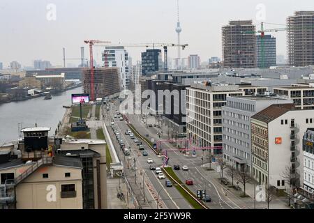 Berlino, Germania. 24 Marzo 2021. Vista di Mühlenstraße presso la East Side Gallery e delle gru di costruzione a Friedrichshain in direzione di Mitte con la torre della televisione. Credit: Jens Kalaene/dpa-Zentralbild/ZB/dpa/Alamy Live News Foto Stock