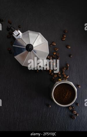 Ancora vita con moka pot e caffè fagioli su nero sfondo di pietra Foto Stock