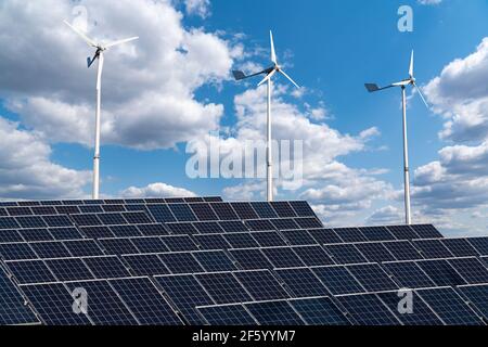 Pannelli solari e turbine eoliche su un campo verde. Concetto di energia sostenibile Foto Stock