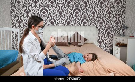 Il medico controlla le gambe del bambino. Foto Stock