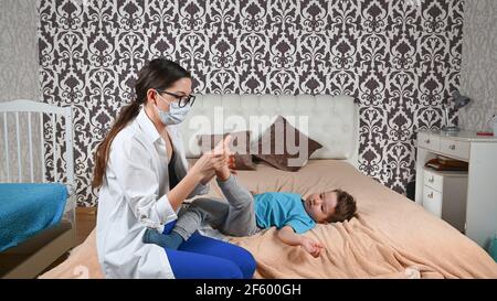 Il medico controlla le gambe del bambino. Foto Stock