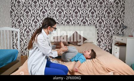 Il medico controlla le gambe del bambino. Foto Stock