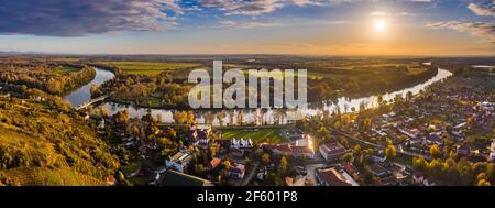 Tokaj, Ungheria - veduta panoramica aerea della città della regione del vino Tokaj con la città di Tokaj con il fiume Tisza e l'alba dorata sullo sfondo su un caldo Foto Stock