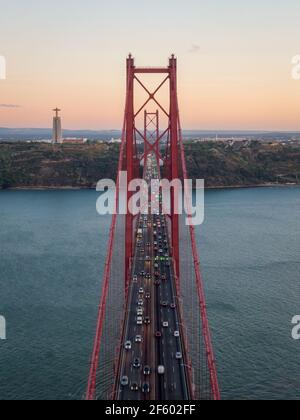Vista aerea del traffico sul ponte del 25 aprile (in portoghese: Ponte 25 de Abril) sul fiume Tago al tramonto a Lisbona, Portogallo. Foto Stock