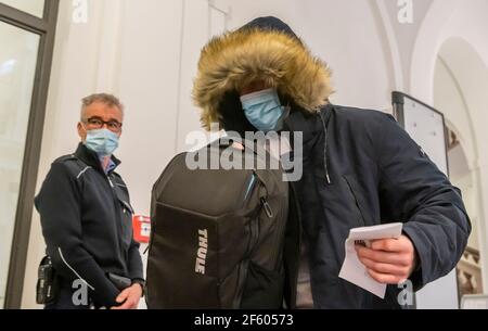 Dresda, Germania. 29 marzo 2021. Uno su un totale di tre imputati viene al Tribunale regionale di Dresda per l'avvio del processo contro i membri del gruppo Faust des Ostens. Gli uomini sono accusati di appartenenza a un'organizzazione criminale, furto e assalto. Essi sono ritenuti responsabili di 'attacchi violenti contro membri di altre squadre di calcio, ufficiali di polizia e persone di aspetto straniero' nelle vicinanze delle partite di calcio dell'allora seconda divisione della squadra Dynamo Dresden. Credit: Matthias Rietschel/dpa-Zentralbild/dpa/Alamy Live News Foto Stock