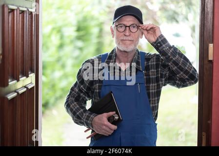 Ritratto di riparatore in piedi all'ingresso di una casa Foto Stock