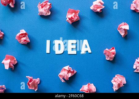 Palline di carta rosa sbriciolati su sfondo blu. Concetto di idea creativa Foto Stock