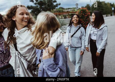 Amici allegri che parlano mentre camminano sul sentiero Foto Stock
