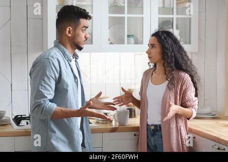 Crisi delle relazioni. Giovane coppia araba che si batte in cucina Foto Stock