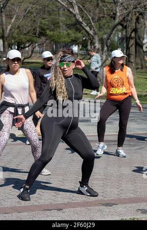 Una donna balla vigorosamente in una lezione di danza Zumba nel Flushing Meadows Corona Park a Queens, New York City. Foto Stock