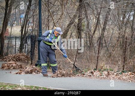 Nel tardo inverno, i dipendenti del Dipartimento di un NYC Park si allontanano in un parco a Queens, New York City. Foto Stock