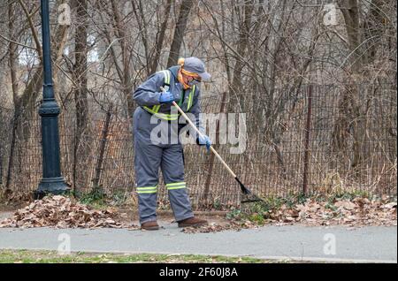 Nel tardo inverno, i dipendenti del Dipartimento di un NYC Park si allontanano in un parco a Queens, New York City. Foto Stock