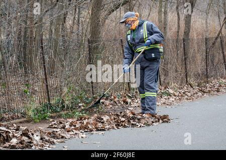 Nel tardo inverno, i dipendenti del Dipartimento di un NYC Park si allontanano in un parco a Queens, New York City. Foto Stock