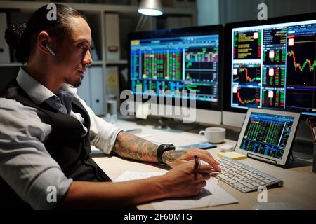 Il commerciante professionale rifinisce in su la giornata rivedendo i commerci, facendo nota di che cosa è andato bene e che cosa potrebbe essere fatto meglio Foto Stock