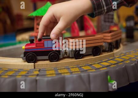 Primo piano foto laterale del trenino giocattolo di controllo a mano dei bambini sulla strada Foto Stock