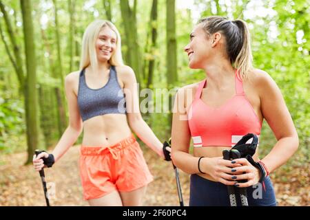 Due amici fanno nordic walking insieme nel loro tempo libero in natura Foto Stock