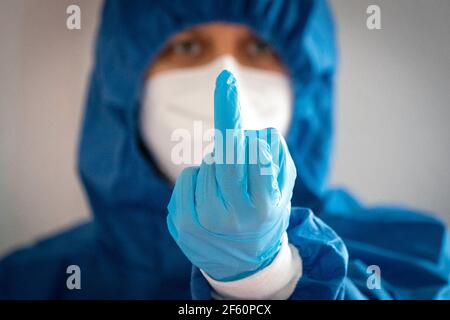 Lipsia, Germania. 23 marzo 2021. ILLUSTRAZIONE: Un cosiddetto 'dito tinky' è mostrato da una donna in indumenti protettivi. Credit: Peter Endig/dpa-Zentralbild/ZB/dpa/Alamy Live News Foto Stock