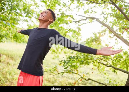 Felice giovane uomo che respira in aria fresca in natura in estate Foto Stock