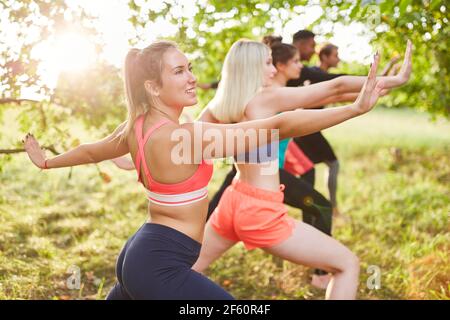 Gruppo di amici che fanno ginnastica tai chi per fitness e. salute in natura Foto Stock