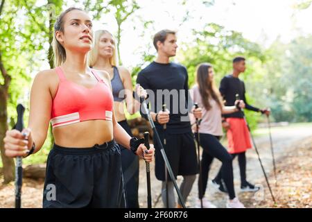 Gruppo di giovani si allenano insieme per la resistenza nel Workshop Nordic Walking Foto Stock