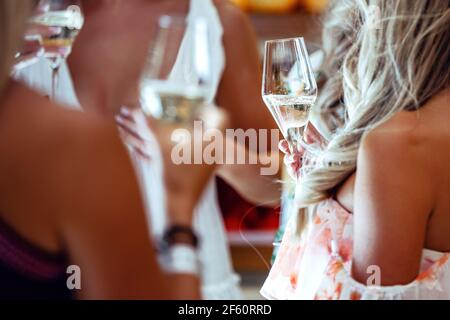 Le mani delle donne tengono bicchieri di champagne. Vino in un bicchiere da vicino Foto Stock