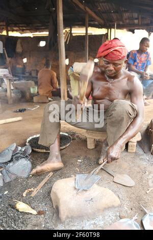 Fabbro che fa le zane per gli agricoltori rurali nello Stato di Oyo, Nigeria. Foto Stock