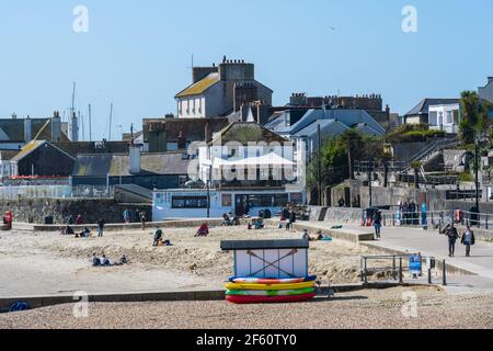 Lyme Regis, Dorset, Regno Unito. 29 marzo 2021. Regno Unito Meteo: La stazione balneare di Lyme Regis crogioli in glorioso caldo sole di primavera, come il coronavirus blocco restrizioni di facile toay. Le temperature sono impostate per salire con la costa sud che vede le condizioni sfrigolanti questa settimana. Credit: Celia McMahon/Alamy Live News Foto Stock