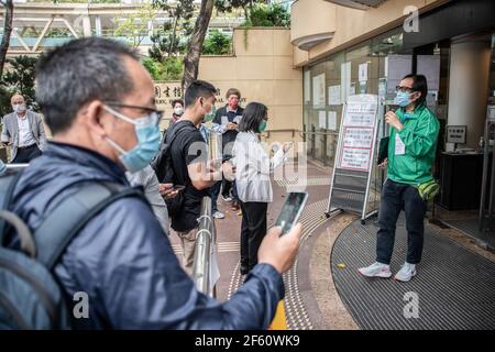 Hong Kong, Cina. 18 Marzo 2021. Un membro del personale del Centro comunitario di vaccinazione parla con i partecipanti fuori dalla Biblioteca Centrale di Hong Kong. I cittadini di Hong Kong frequentano il Centro comunitario di vaccinazione situato in una delle gallerie della Biblioteca Centrale di Hong Kong, nel distretto di Tai Hang, giovedì 18 marzo. Credit: Ivan Abreu/SOPA Images/ZUMA Wire/Alamy Live News Foto Stock