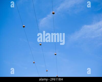 Palline segnalatrici aeree su linee elettriche trifase a 11 kv contro un cielo blu nel Regno Unito. Foto Stock