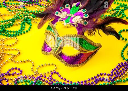 Fat Martedì tradizionale accessorio e Mardi Gras carnevale tema con primo piano su una maschera pieno di colore, piume e texture e colorato Foto Stock