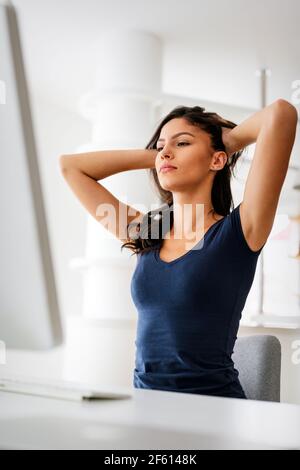 Giovane bella donna d'affari stanca dal lavoro sul computer. Tecnologia, concetto di persone Foto Stock