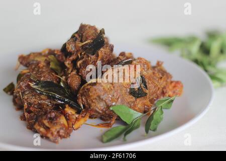 Arrosto di montone in stile Kerala preparato con olio di cocco. Scatto su sfondo bianco Foto Stock