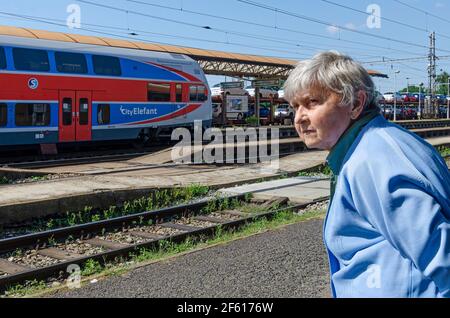 Donna anziana in attesa di un treno nella stazione ferroviaria, Lysa nad Labem, Repubblica Ceca Foto Stock