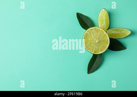 Lime e foglie fresche su sfondo di menta Foto Stock