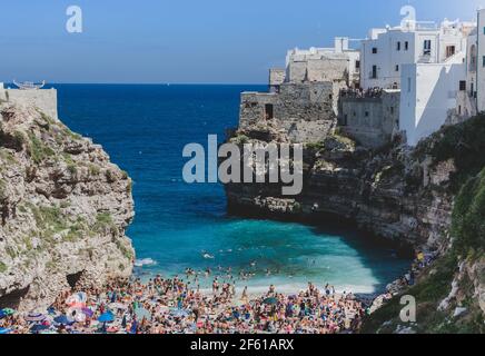 Polignano a Mare, Italia - 12 agosto 2014: Turisti in vacanza estiva alla spiaggia Cala Paura, una delle più belle del Mare Adriatico. Il canto famoso Foto Stock