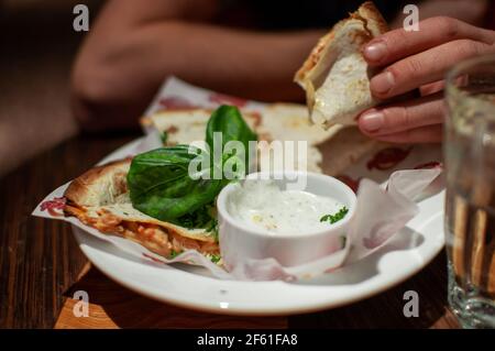 Uomo che mangia deliziosa quesadilla al ristorante Foto Stock