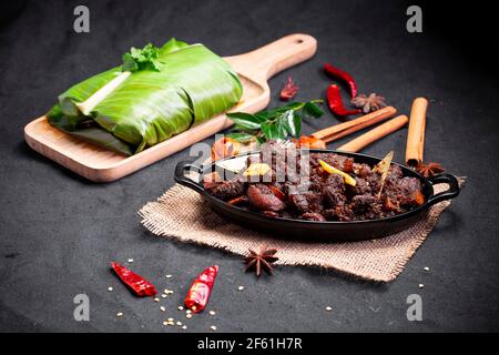 Arrosto di manzo o pothu ulartheyadu, piatto speciale kerala disposto in una tavola nera e in foglia di banana in modo tradizionale posto su un colore nero Foto Stock